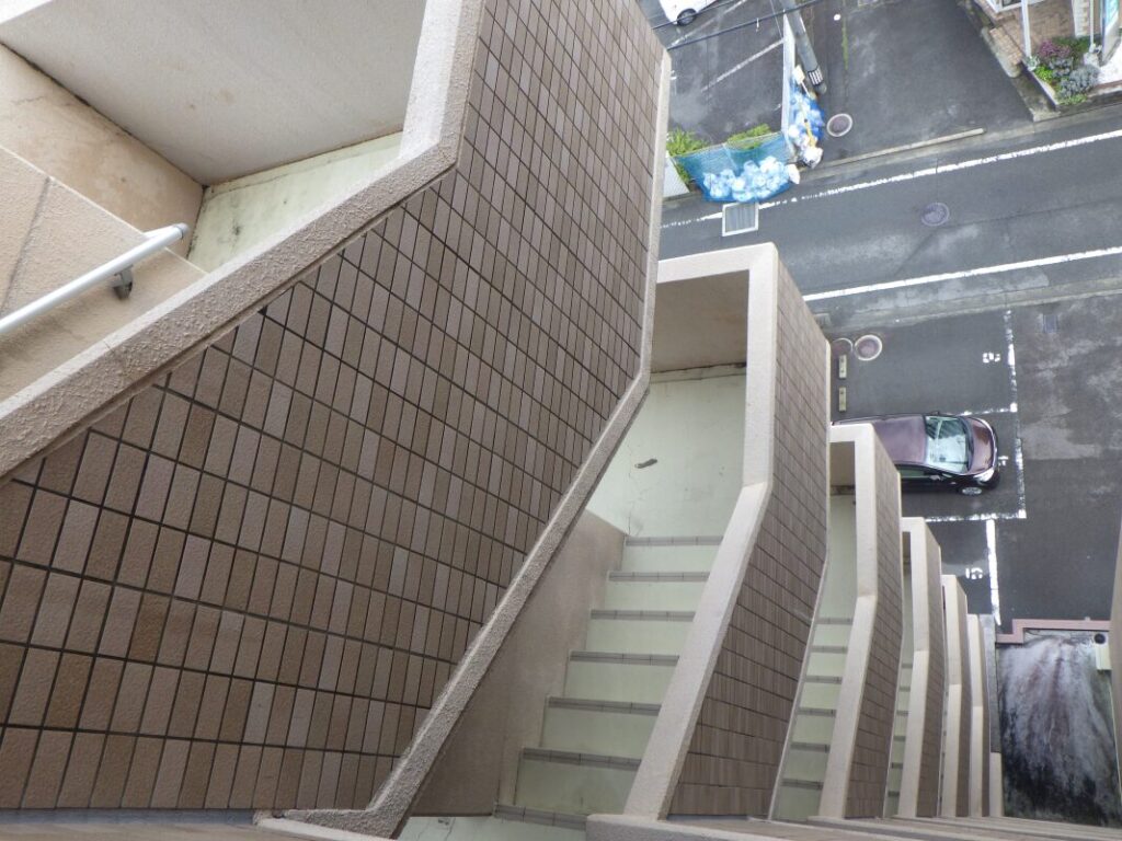 階段土間の塗装前の床面。汚れや劣化箇所を確認し、下地処理の必要性を判断している状態。